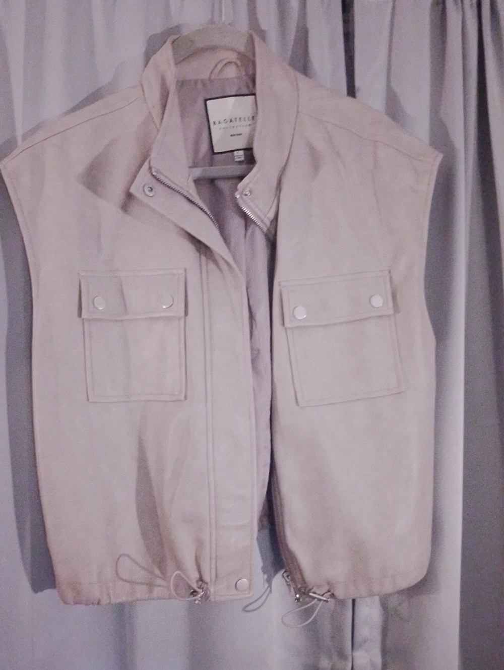 A chic, contemporary utility vest crafted in a soft Grey faux leather.